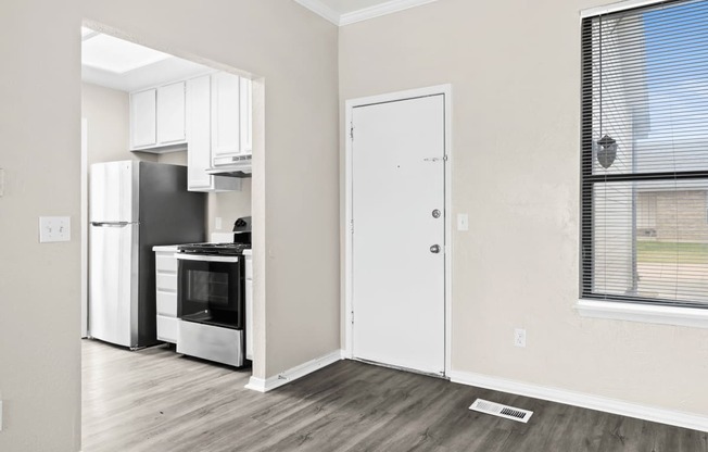 an empty room with a kitchen and a window and a refrigerator at Diamond Ridge Townhomes, Oklahoma ,73114