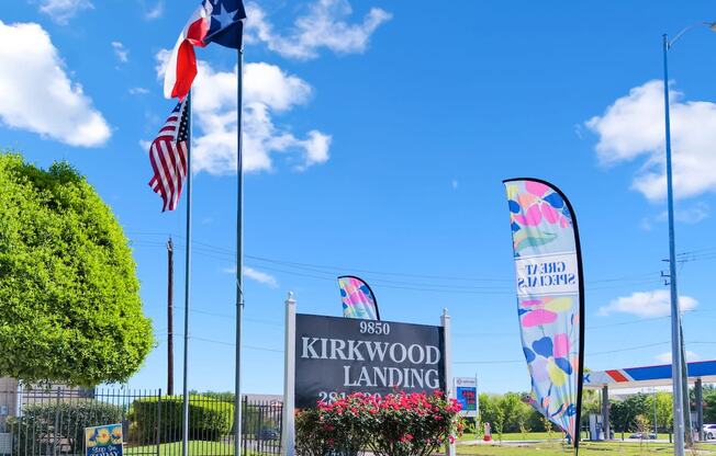 the entrance to kirkwood landing with flags and a sign