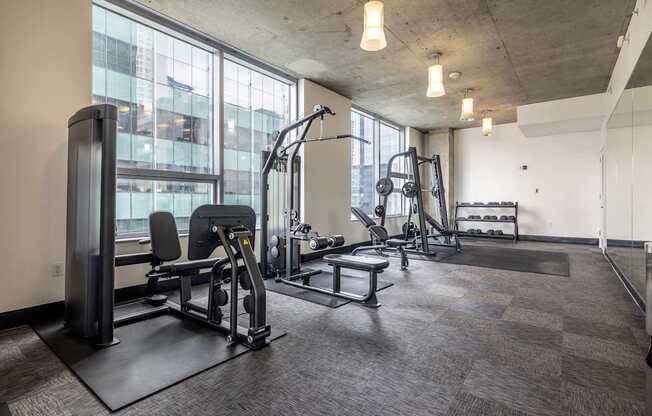 A gym with a variety of equipment including a treadmill, weights, and a bench press.