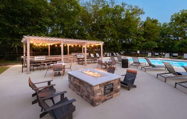 a patio with a fire pit and a pool with chairs and tables