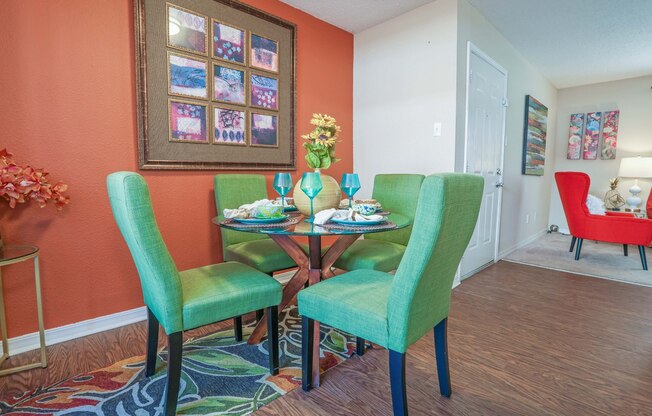 Furnished model apartment dining room with table and green chairs at Magnolia apartments in Shreveport, LA
