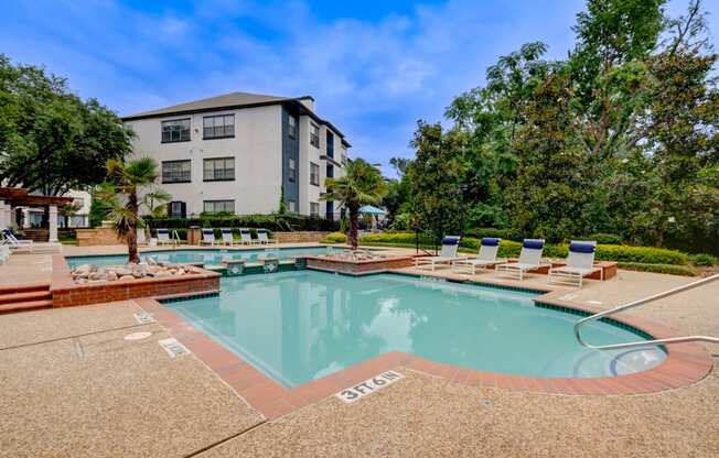 a swimming pool with chairs and a building in the background