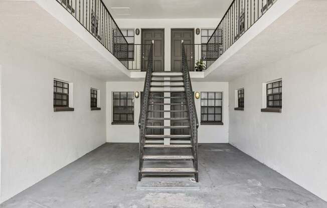 A staircase in a white building with black railings.