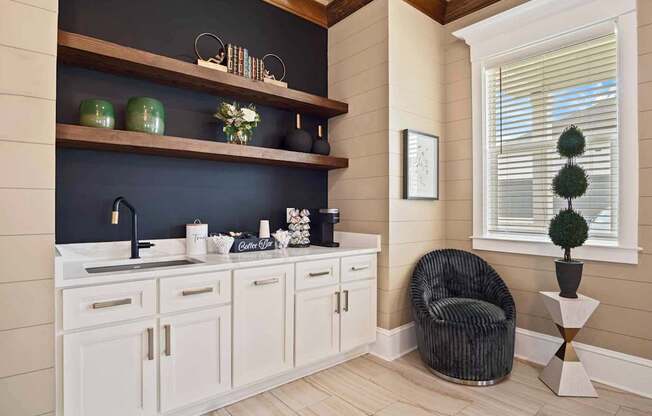 A kitchen with white cabinets and a black countertop.