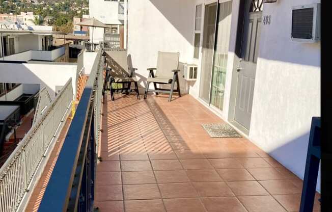 A balcony with a table and chairs overlooking a town.