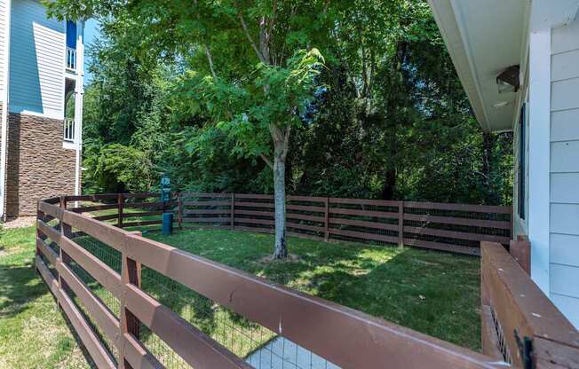 A brown fence surrounds a green lawn.