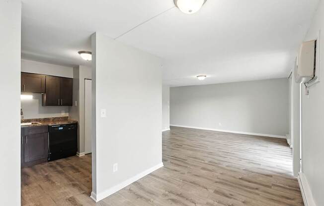 A room with a kitchen area and a dining table.