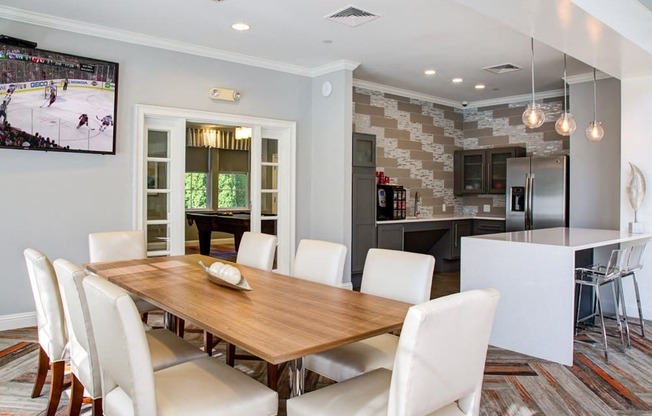 A modern dining room with a wooden table and white chairs.