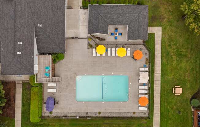 arial view of a backyard with a swimming pool and umbrellas