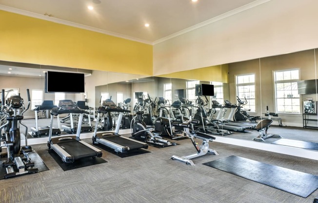 a large fitness room with cardio equipment and flat screen televisions at Meridian Park in Collierville, TN 38017