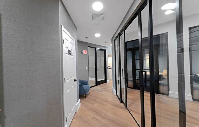 A hallway with a blue chair and a white door.