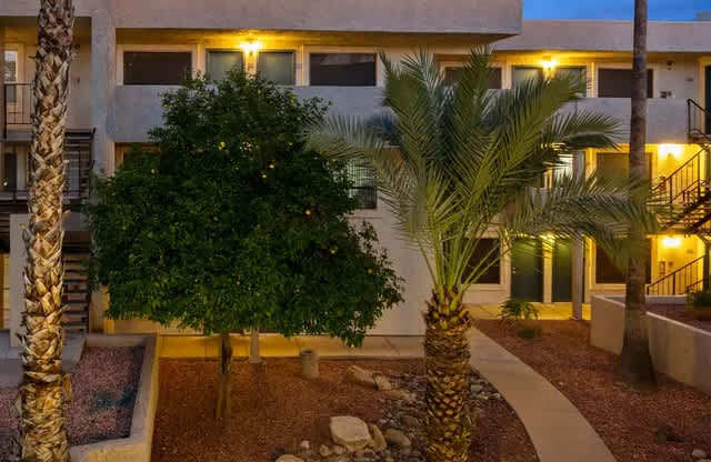 A building with a courtyard surrounded by palm trees.