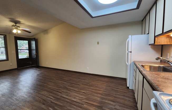 a kitchen and living room with a refrigerator and a sink