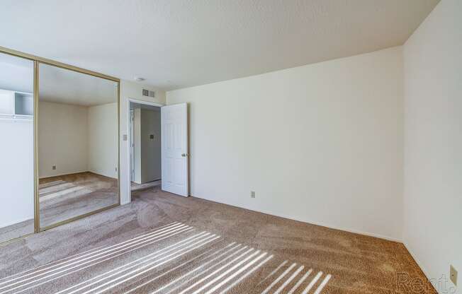 a bedroom with a large mirror and a carpeted floor at Terrace View Apartments, Daly City, 94015 