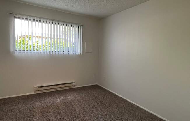 an empty bedroom with a window