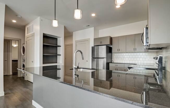 a kitchen with a large center island with a sink and a chrome faucet