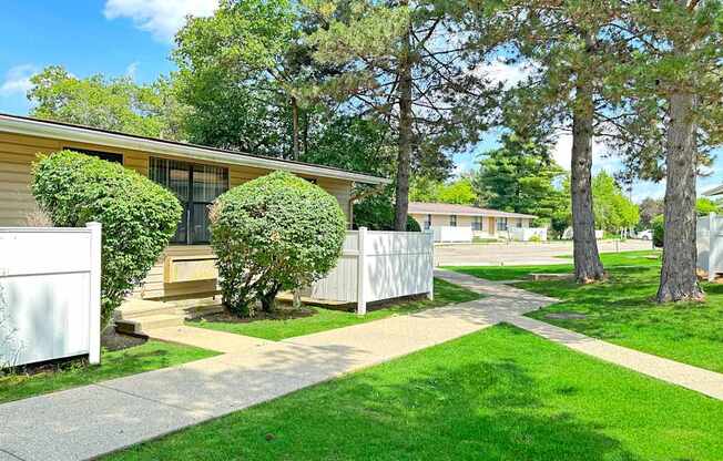 A house with a white picket fence and a green lawn.