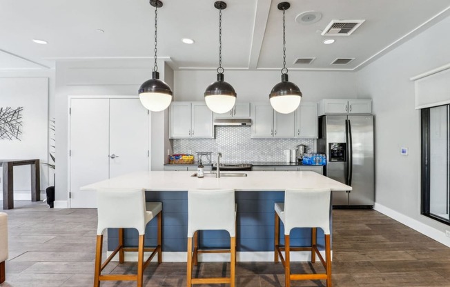 a kitchen with a large island with four chairs in front of it