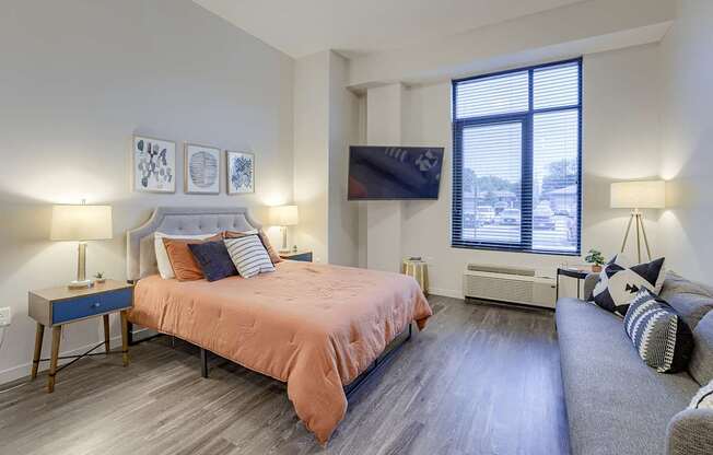 A bedroom with a large bed and a couch.