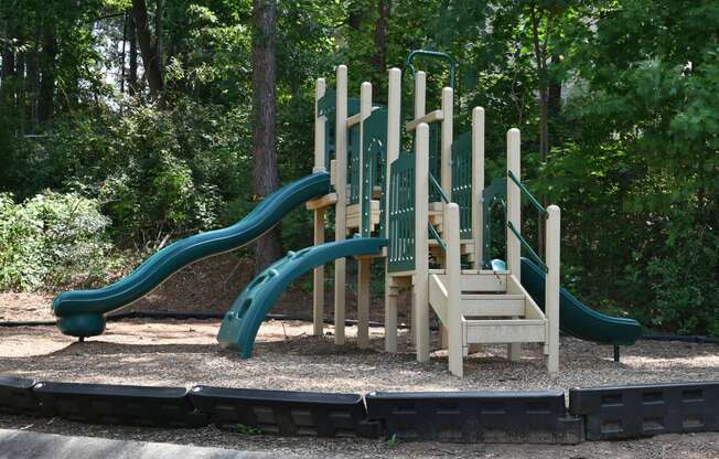 a playground with a set of slides in a park