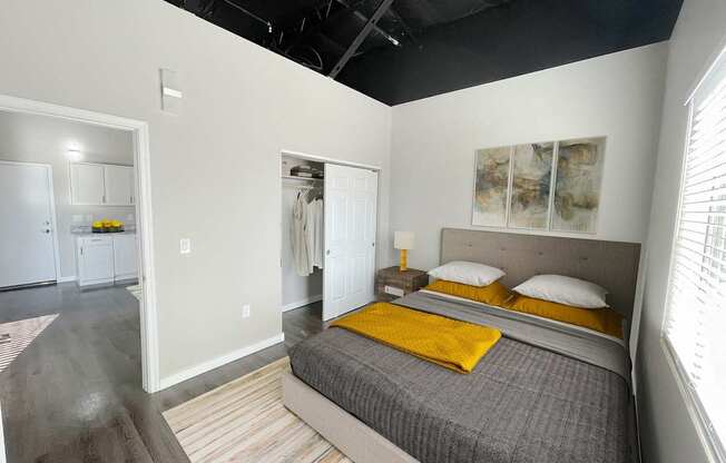 A bedroom with a bed, nightstand, and a painting on the wall.