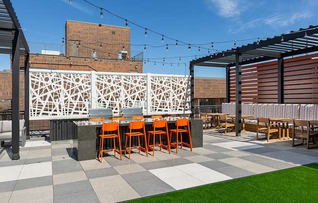 A patio with grassy area and orange chairs.