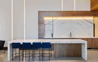 a kitchen with a marble counter top and blue chairs at The Paxton, Brooklyn, New York