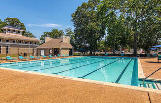 A large swimming pool with a building in the background.