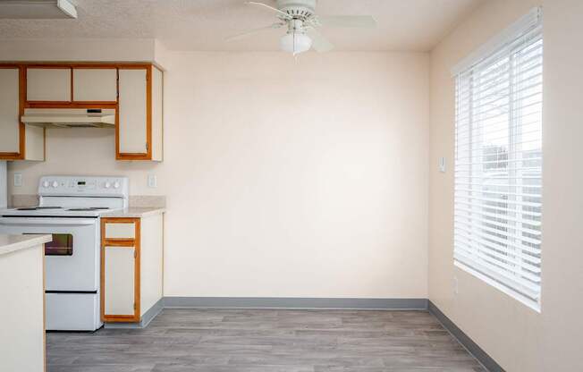 A kitchen with a white oven and wooden cabinets.