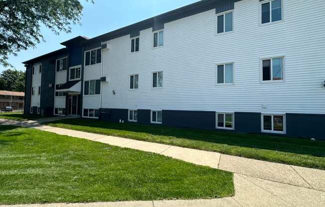 an exterior view of a white and blue apartment building