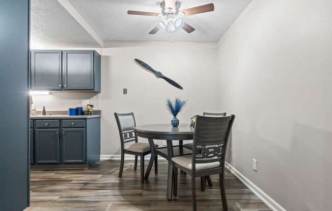 a dining room with a table and chairs and a ceiling fan