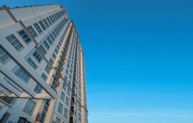 the tall apartment building with a blue sky in the background of Dominion Post Oak  in Houston, TX