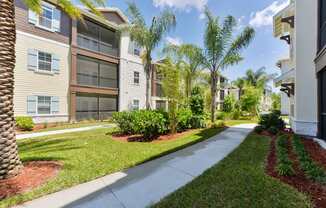 A row of apartment buildings with a sidewalk in front.