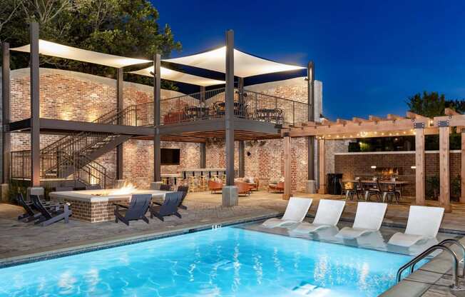 a swimming pool at a resort with a poolside bar and patio furniture