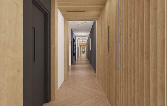 a long hallway with wood floors and black doors