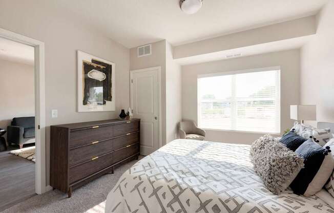 A bedroom with a large bed and a dresser.
