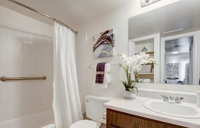 A white bathroom with a white tub, sink, and toilet.