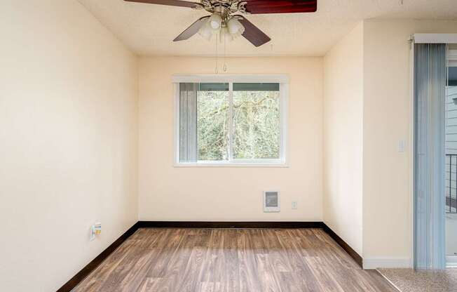 A room with a ceiling fan and a window.