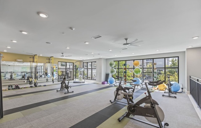a gym with exercise equipment and windows at the estates apartments