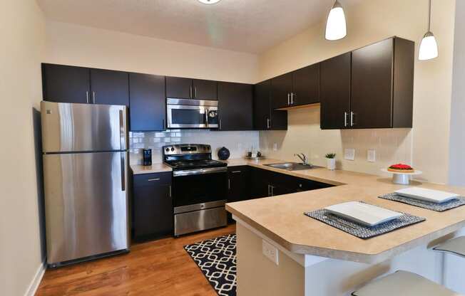 a kitchen with stainless steel appliances and black cabinets