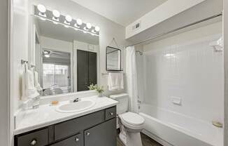 A bathroom with a sink, mirror, and towel rack.