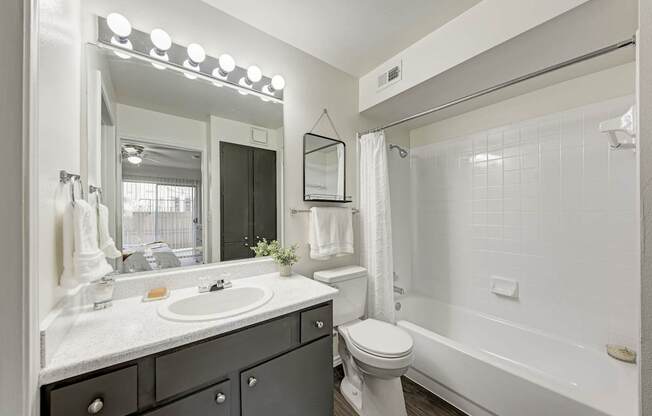 A bathroom with a sink, mirror, and towel rack.