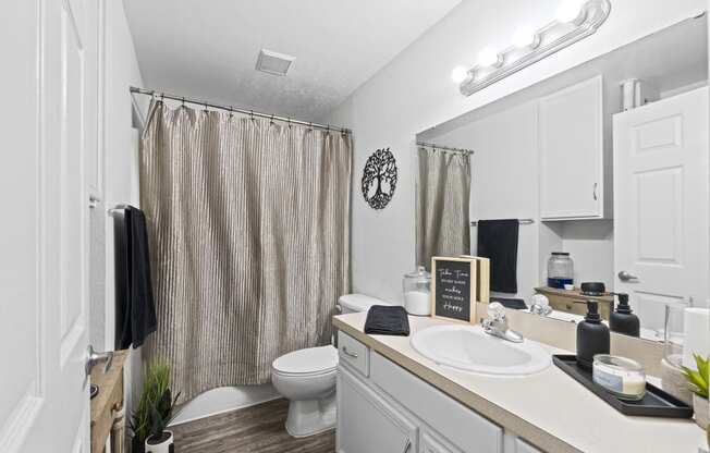 a bathroom with a shower and a sink and a toilet