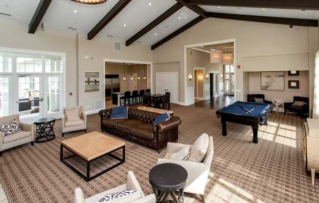 a large living room with a pool table and couches at The Winhall of Williams Pointe Apartments, Waukee, IA, 50263