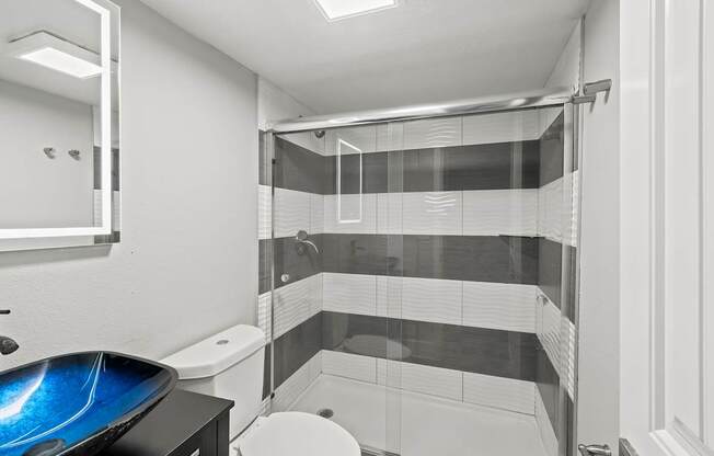 A bathroom with a toilet, sink, and shower.