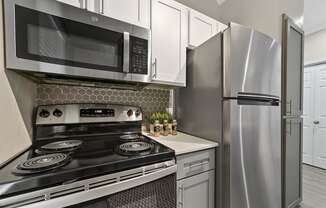 a kitchen with white cabinets and stainless steel appliances