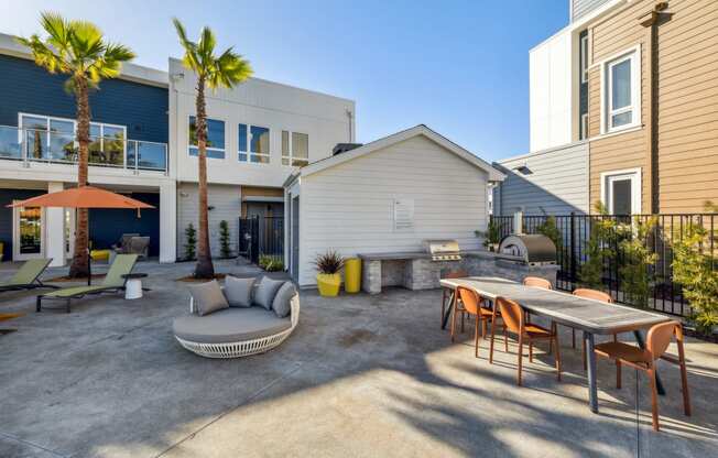 a patio with a table and chairs and a couch in front of a house