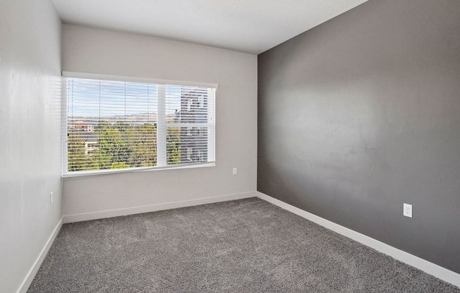 an empty bedroom with a large window