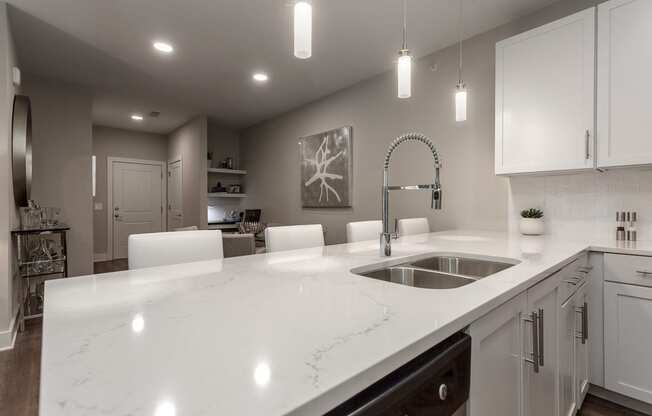 an open kitchen with white counter tops and a sink