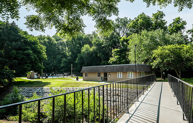 a bridge crosses a pond in front of a building